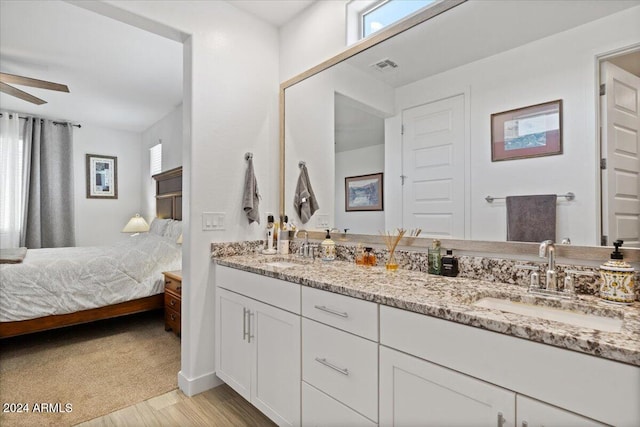 bathroom with hardwood / wood-style floors, ceiling fan, and vanity