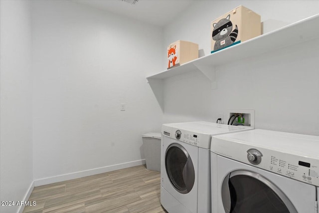 laundry area featuring light hardwood / wood-style flooring and washing machine and dryer