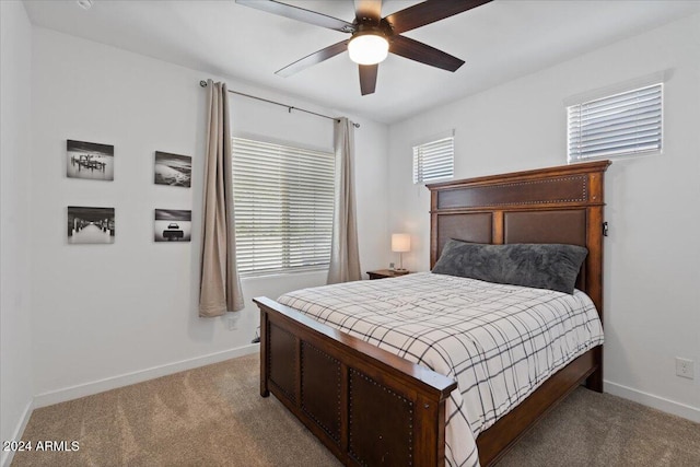 carpeted bedroom featuring ceiling fan and multiple windows