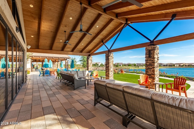 view of patio with a water view, ceiling fan, an outdoor hangout area, and a gazebo