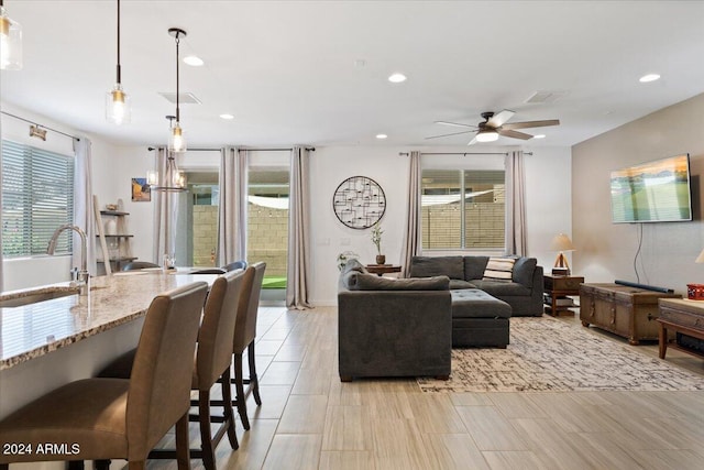 living room with sink, ceiling fan, and plenty of natural light