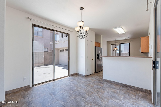 1244 S Tacoma, Mesa, AZ 85209 - unfurnished dining area featuring baseboards, stone finish flooring, and a chandelier