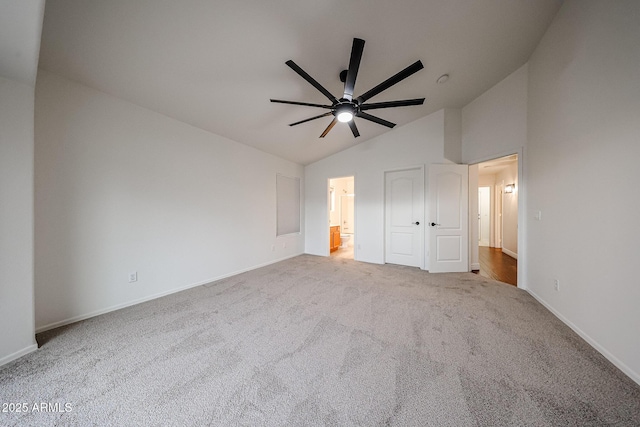 unfurnished bedroom with ceiling fan, lofted ceiling, and light carpet