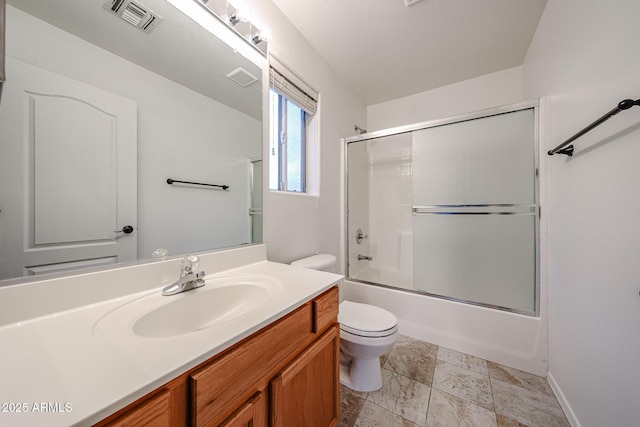 full bathroom featuring vanity, combined bath / shower with glass door, and toilet