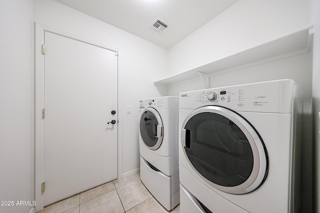 washroom with light tile patterned floors and washing machine and clothes dryer