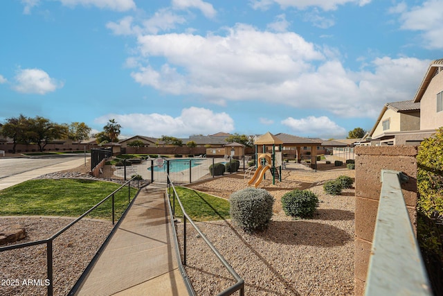 view of yard with a playground and a community pool