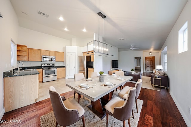 dining space with sink, hardwood / wood-style floors, and a notable chandelier