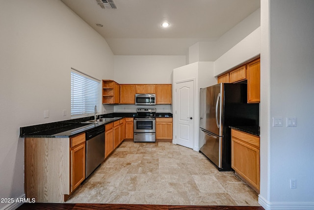 kitchen featuring sink, stainless steel appliances, dark stone counters, and high vaulted ceiling