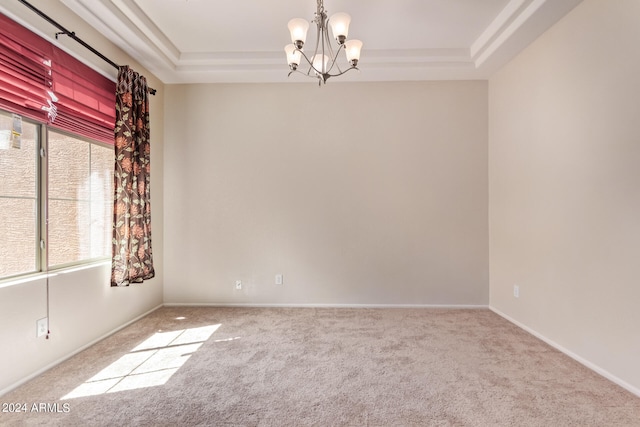 unfurnished room featuring a chandelier, carpet floors, and a tray ceiling