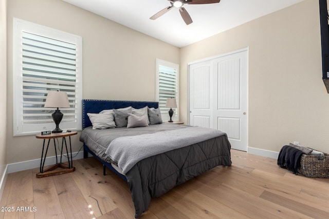 bedroom featuring a ceiling fan, baseboards, a closet, and wood finished floors