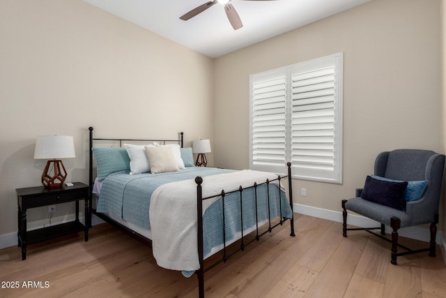 bedroom featuring baseboards, light wood-type flooring, and ceiling fan