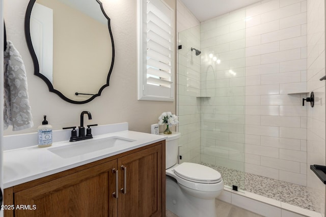 full bath with toilet, a tile shower, and vanity