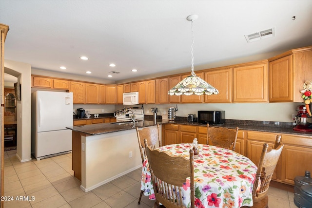 kitchen featuring sink, pendant lighting, white appliances, a kitchen island with sink, and light tile patterned floors