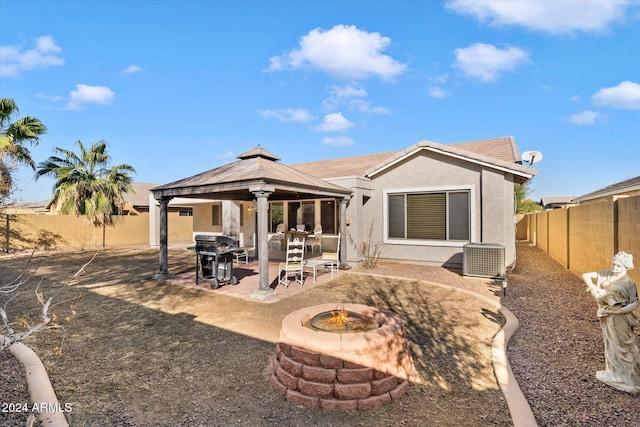 back of house with a gazebo, cooling unit, a patio, and a fire pit