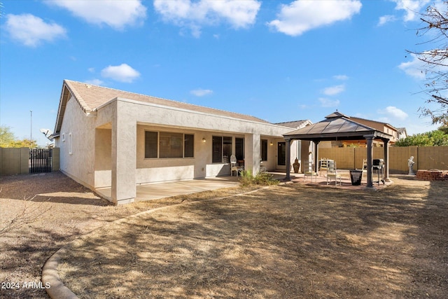 back of property featuring a gazebo and a patio