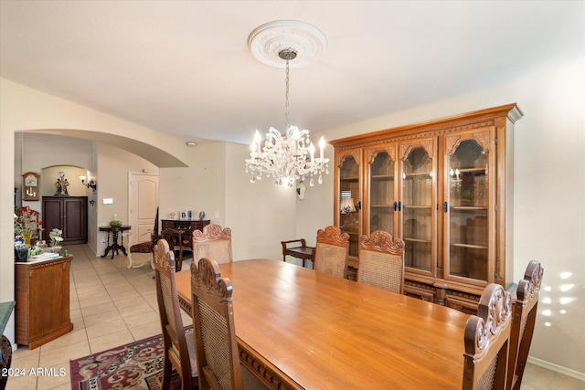 dining area with light tile patterned flooring and an inviting chandelier