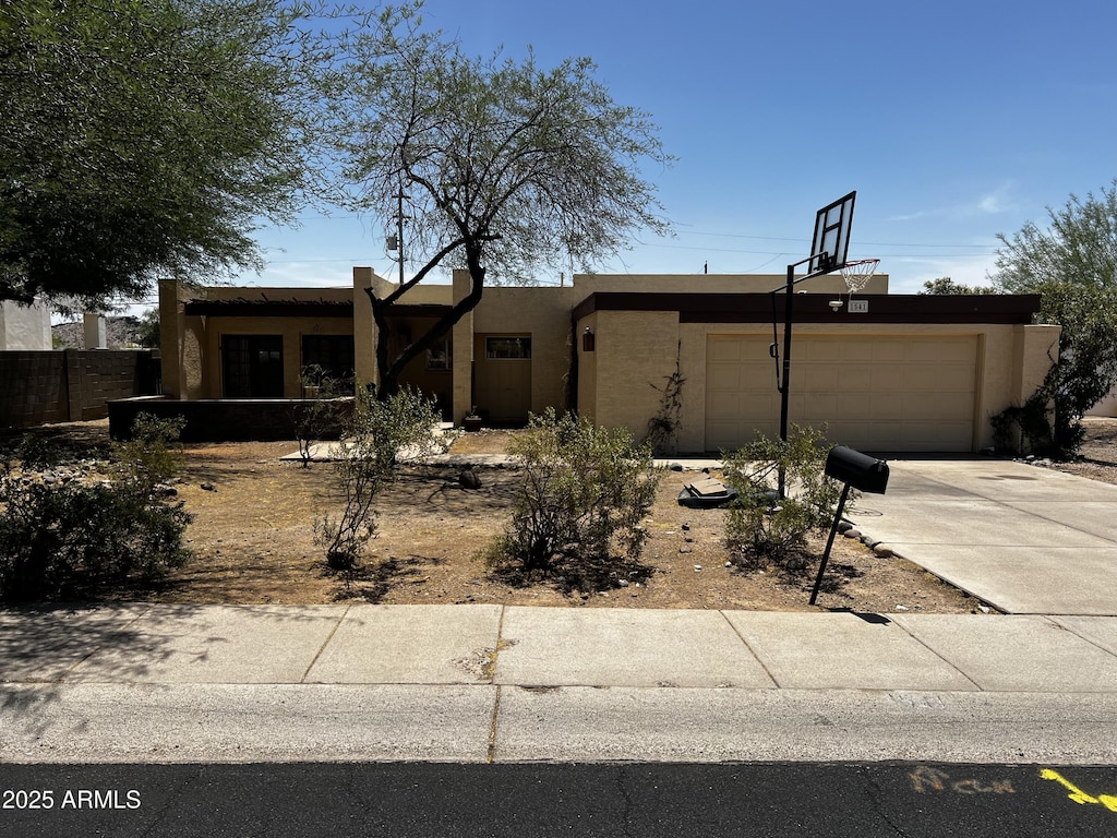 view of front of house with a garage, stucco siding, and concrete driveway