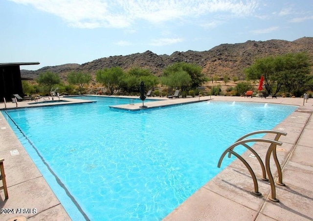 view of swimming pool featuring a patio, a mountain view, and pool water feature