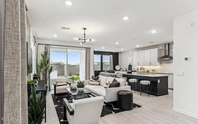 living room with sink and light hardwood / wood-style flooring