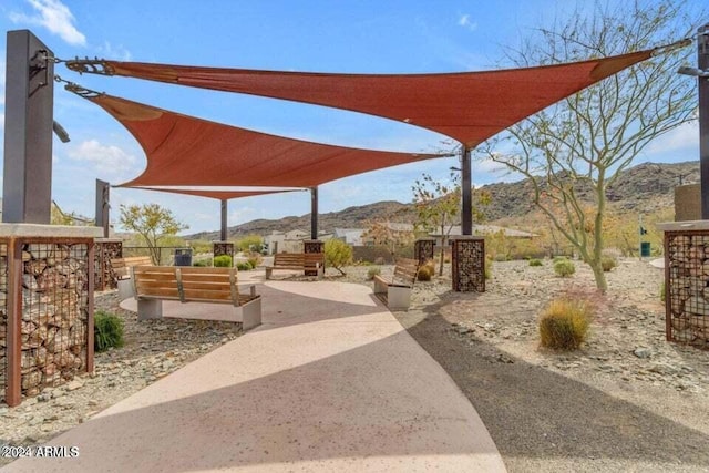 surrounding community with a mountain view and a patio area