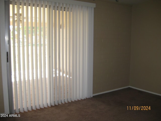 unfurnished room featuring dark carpet