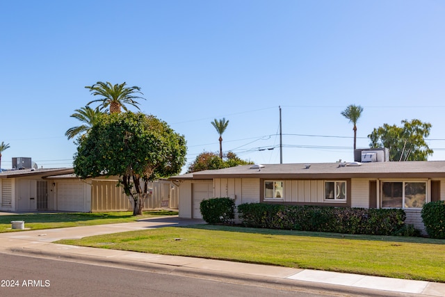 single story home featuring a garage and a front lawn