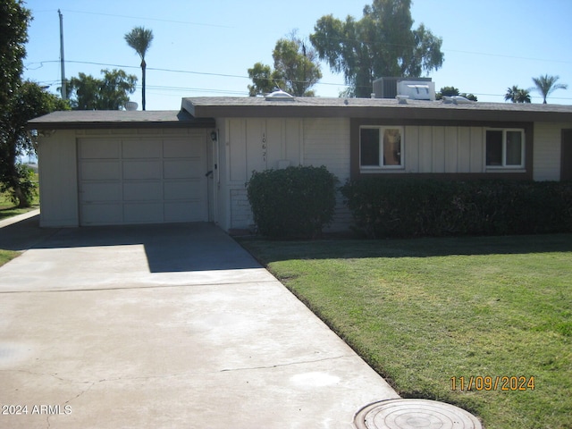 single story home featuring a garage and a front lawn