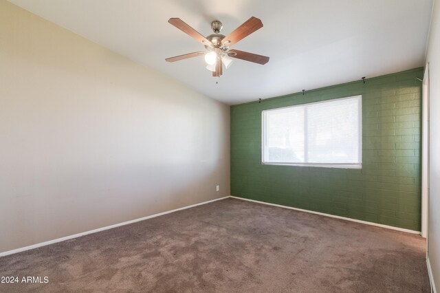 empty room featuring dark carpet and ceiling fan