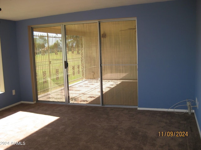 doorway to outside featuring dark carpet