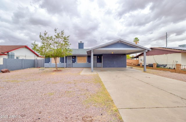 418 E 5th St, Eloy, AZ 85131 - view of front of home with fence, concrete driveway, a chimney, and a carport