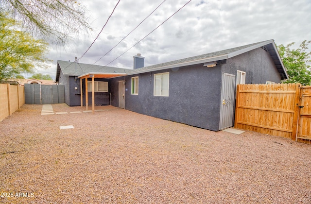418 E 5th St, Eloy, AZ 85131 - rear view of house with a gate, a fenced backyard, stucco siding, and a chimney