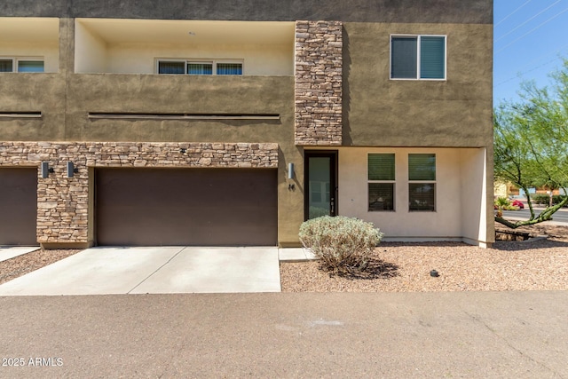 2000 N 36th St Unit 14, Phoenix, AZ 85008 - view of front facade with stucco siding, concrete driveway, a garage, and stone siding