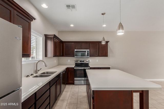 2000 N 36th St Unit 14, Phoenix, AZ 85008 - kitchen featuring stainless steel appliances, light tile patterned floors, light countertops, a kitchen island, and decorative light fixtures