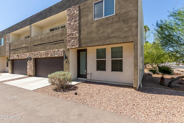 2000 N 36th St Unit 14, Phoenix, AZ 85008 - view of front of property featuring a garage, driveway, stucco siding, and stone siding