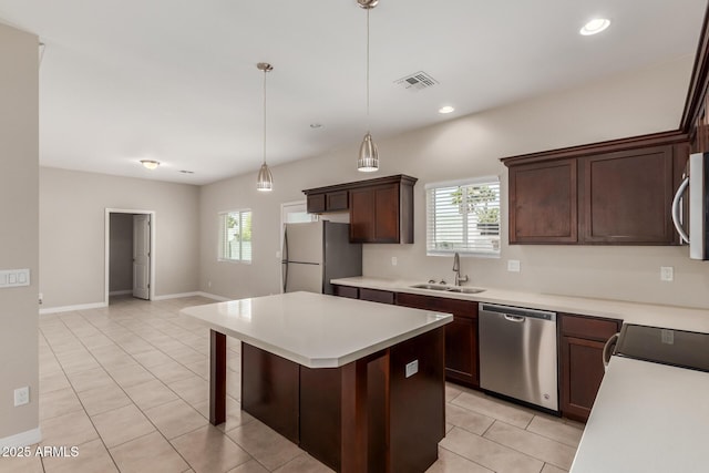 2000 N 36th St Unit 14, Phoenix, AZ 85008 - kitchen featuring appliances with stainless steel finishes, light tile patterned floors, light countertops, hanging light fixtures, and dark brown cabinets