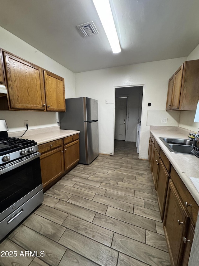 418 N 14th St, Phoenix, AZ 85006 - kitchen with stainless steel appliances, wood tiled floors, light countertops, and brown cabinets