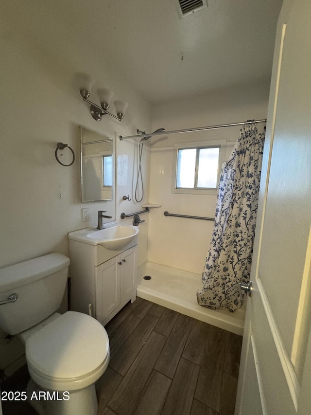418 N 14th St, Phoenix, AZ 85006 - bathroom with vanity, a shower with curtain, toilet, and wood finished floors