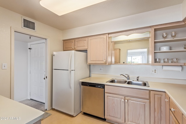 kitchen with sink, light brown cabinetry, light tile patterned floors, white fridge, and dishwasher