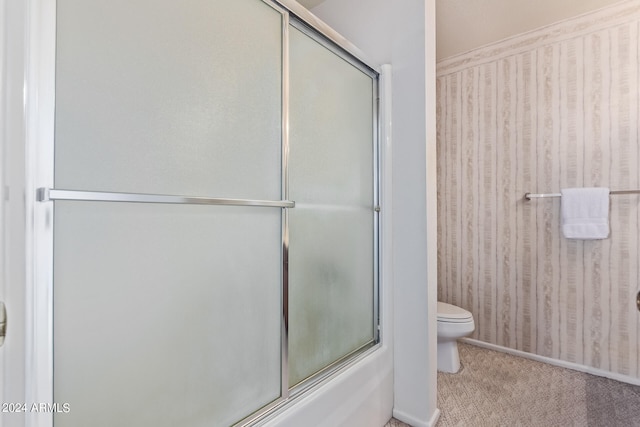 bathroom with shower / bath combination with glass door and toilet