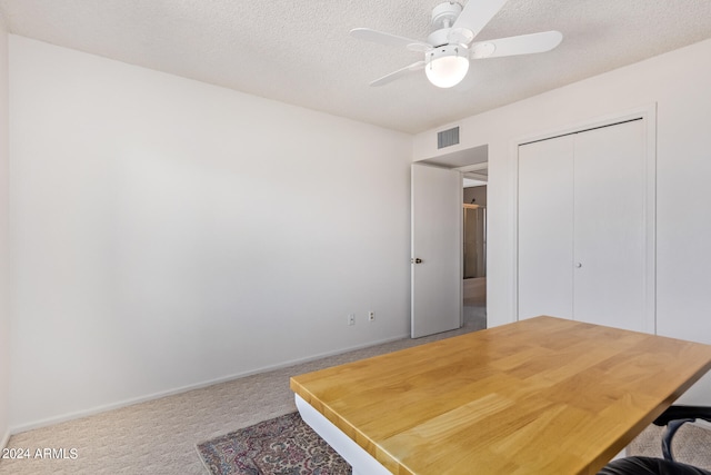 office area with ceiling fan, a textured ceiling, and carpet