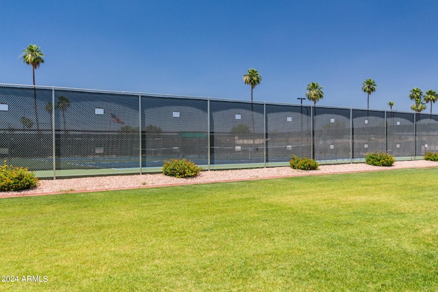 view of tennis court with a yard