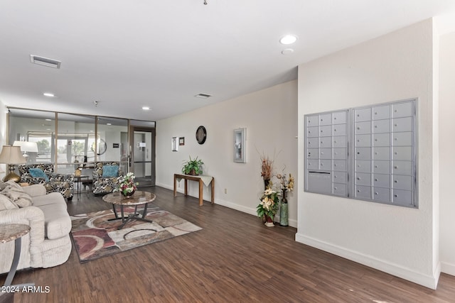 living room with a mail area and dark hardwood / wood-style floors