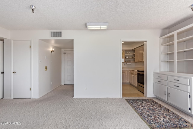 interior space featuring light colored carpet and a textured ceiling