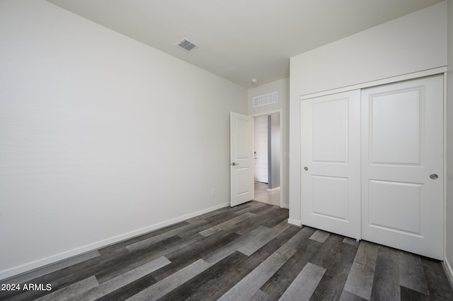 unfurnished bedroom featuring a closet and dark hardwood / wood-style floors