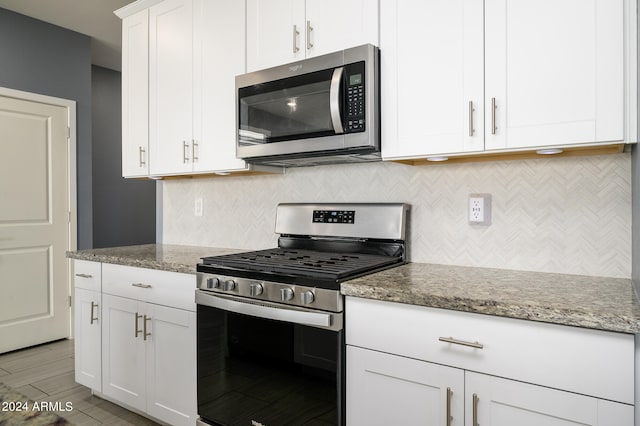 kitchen featuring decorative backsplash, stainless steel appliances, white cabinets, light stone counters, and light hardwood / wood-style floors