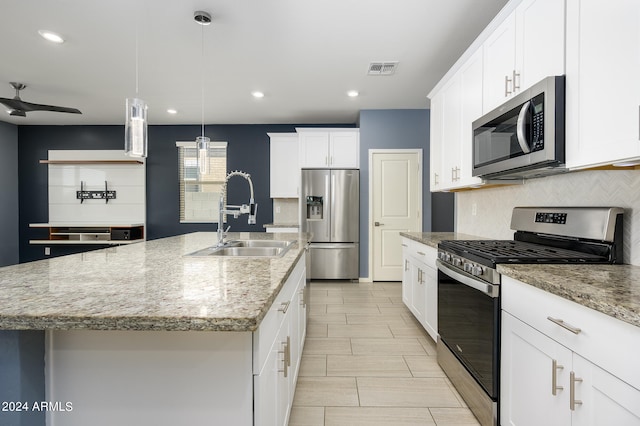 kitchen with sink, an island with sink, decorative light fixtures, and stainless steel appliances