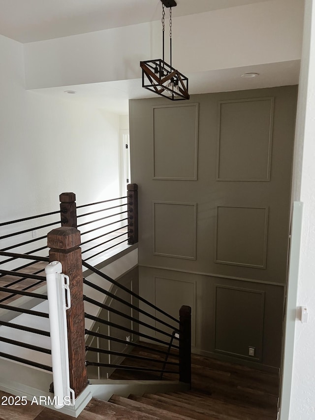 stairs featuring a chandelier