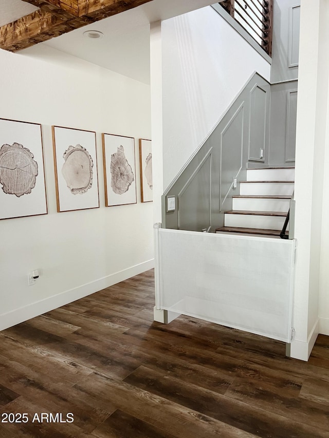 stairway featuring beam ceiling and wood-type flooring