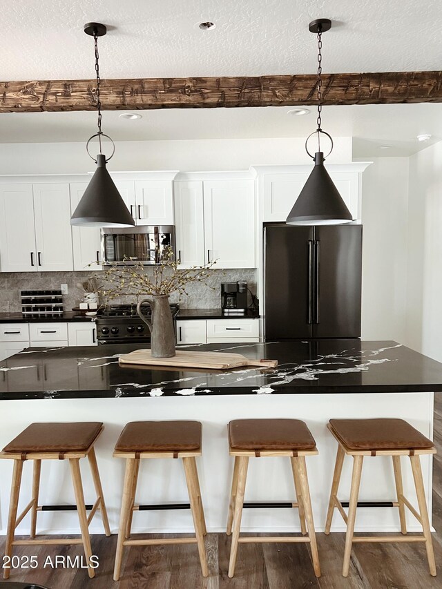 kitchen featuring beamed ceiling, stainless steel fridge, dark hardwood / wood-style flooring, and white cabinetry