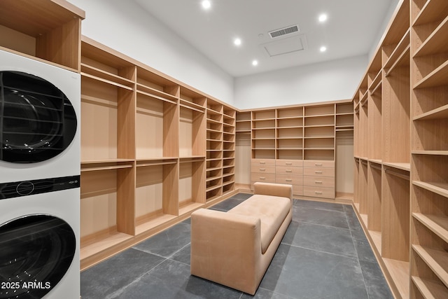 walk in closet with visible vents and stacked washer / drying machine